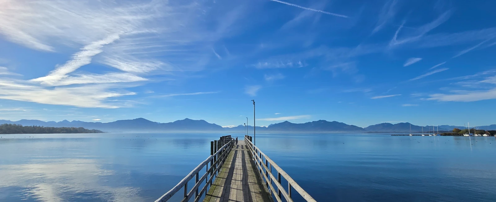 Wunderschöner Blick auf den Chiemsee. Blauer Himmel und Schleierwolken