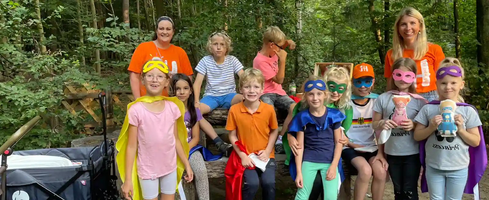 Geschwisterkinder stolz im Wald mit Superheldenkostümen